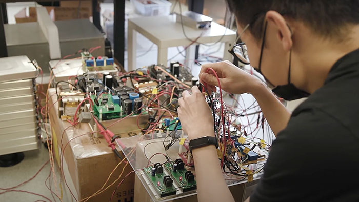An electrical engineering student wires a circuitboard